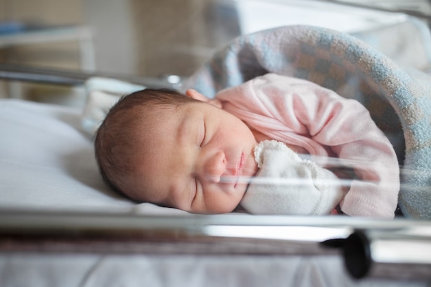 Een pasgeboren baby in het ziekenhuis ligt in de doos. de kleine baby slaapt vlak na de geboorte.