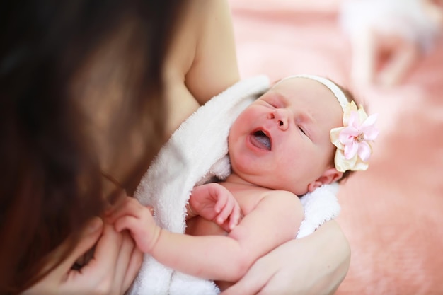 Een pasgeboren baby ligt in de armen van haar moeder. Een mooie baby van Europees uiterlijk slaapt.