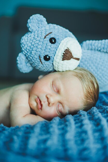 Foto een pasgeboren baby slaapt met een gebreide teddybeer kinderen gebreide speelgoed babyslaap