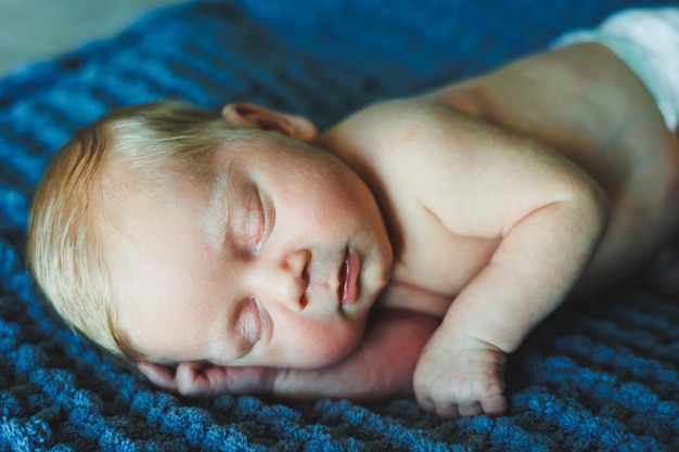 Een pasgeboren baby slaapt op een gebreide deken Een deken gemaakt van natuurlijke stof voor een pasgeboren baby Baby slaap