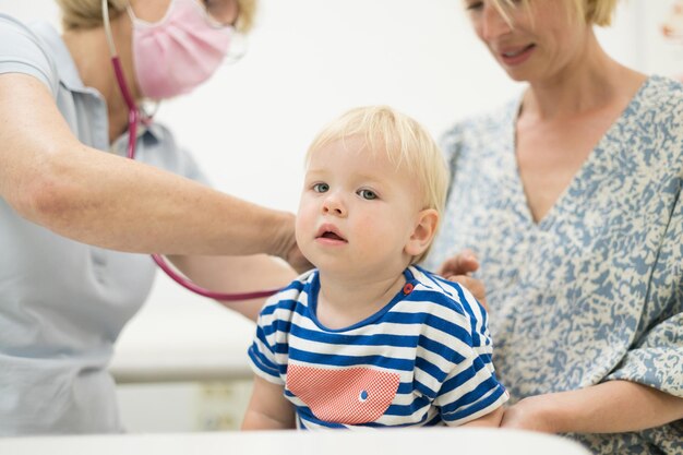 Een pasgeboren jongen wordt onderzocht door zijn kinderarts tijdens een standaard medische check-up in