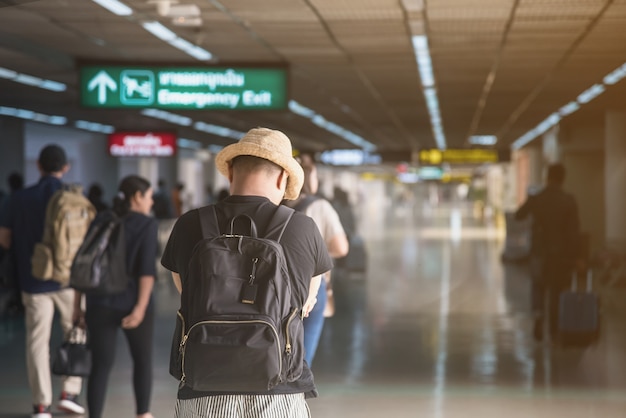 Een passagier met strohoed op de vertrekzone op de luchthaven.