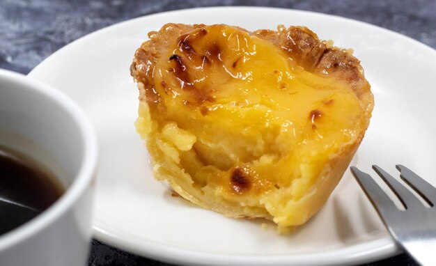 Foto een pastel de nata of portugese eiertart op een wit bord pastel de belm is een kleine taart met een