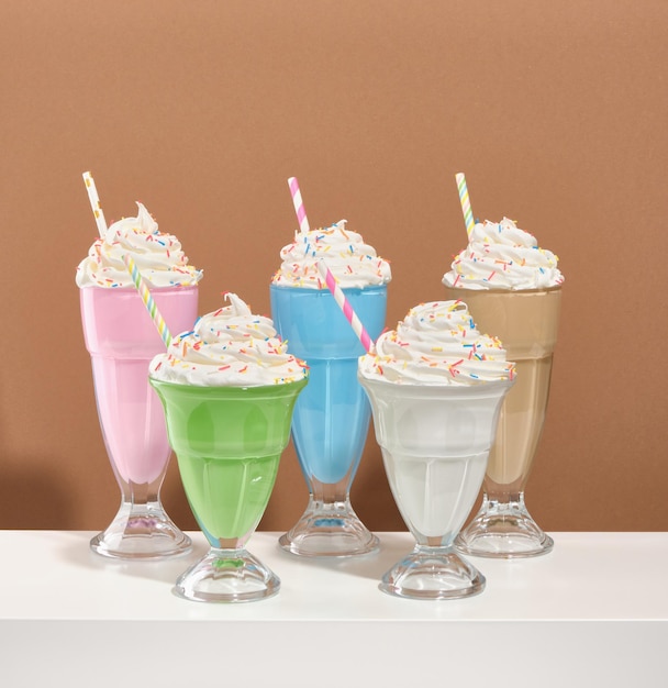 Een patroon van lekkere lekkere zoete delicate milkshakes met hagelslag en gekleurde rietjes vieren