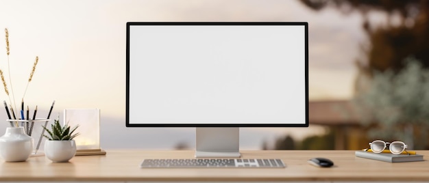 Een pc-model en accessoires op een houten bureau met een wazige achtergrond van een buitenruimte