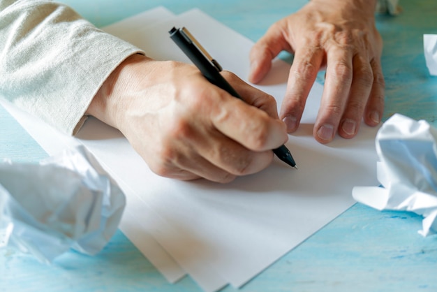 Een pen in de hand van een man. Wit vel papier. Een document ondertekenen.