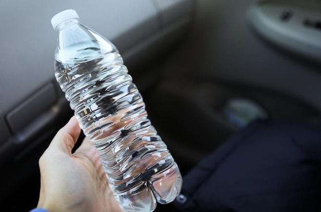 Een persoon die een fles water in zijn hand houdt