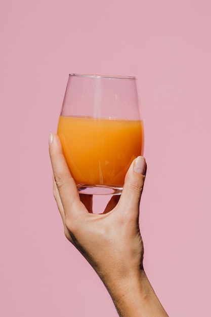 Foto een persoon die een glas sinaasappelsap vasthoudt