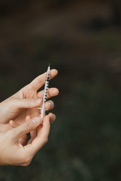 Een persoon die een injectiespuit vasthoudt met het woord griep erop