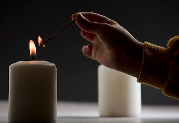 Foto een persoon die een kaars aansteekt met een lucifer in de hand