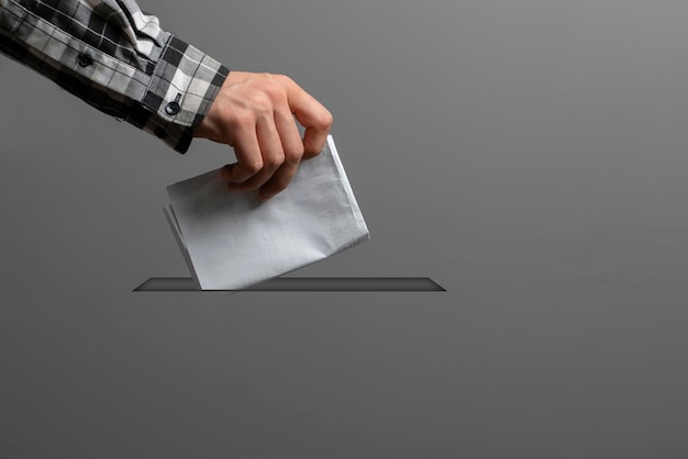 Een persoon die een papieren bulletin vasthoudt en in het minimalistische stemconcept van de urn laat vallen