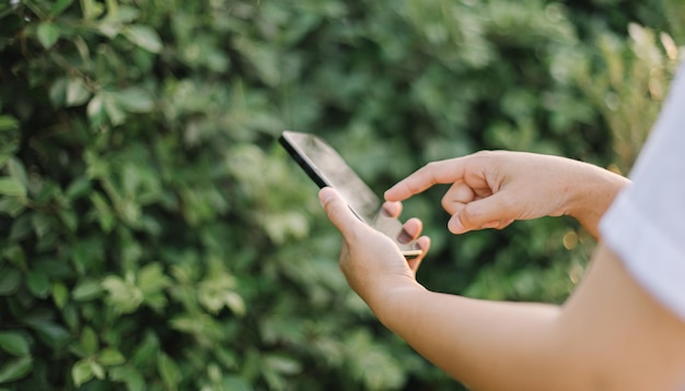 Een persoon die een smartphone gebruikt met een vinger die naar het scherm wijst.