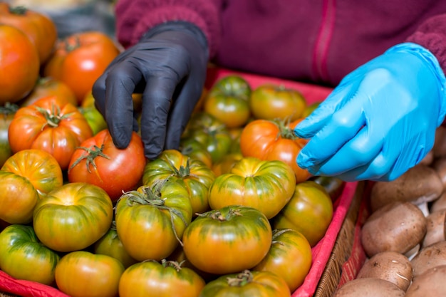 Een persoon die een stapel tomaten maakt op een markt