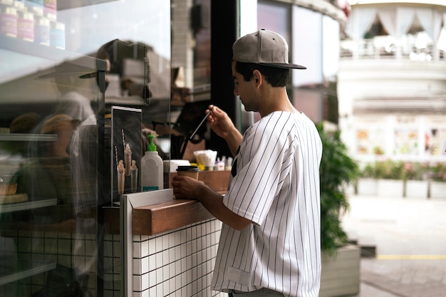 Een persoon die eten en koffie koopt in het straatcafé in de stad