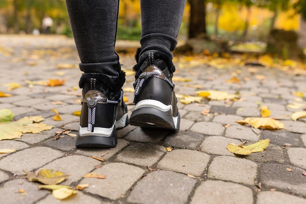 Foto een persoon die zwarte schoenen draagt met het woord adidas op de zijkant.