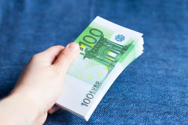 Een persoon geeft een pakje euro-valuta