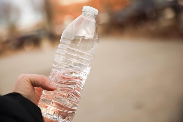 Een persoon houdt een fles water vast.