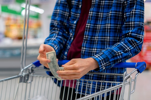 Een persoon in een supermarkt, handen tellen de geldvaluta