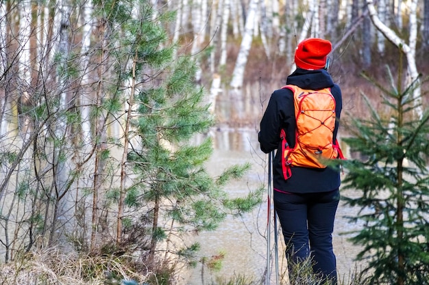 Een persoon in heldere kleren observeert een natuurpad met veel bomen