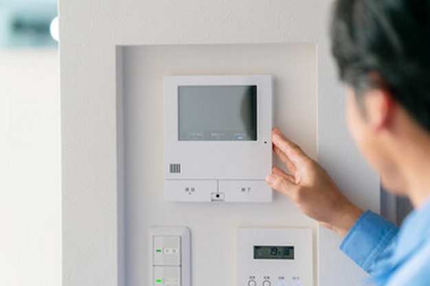 een persoon kijkt naar een digitaal scherm dat aan een muur is bevestigd