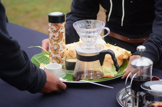 Een persoon serveert een bord eten met een glazen bakje waarop 'het woord koffie' staat.