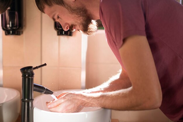 Een persoonlijke hygiëne, een man die handen wast in de gootsteen