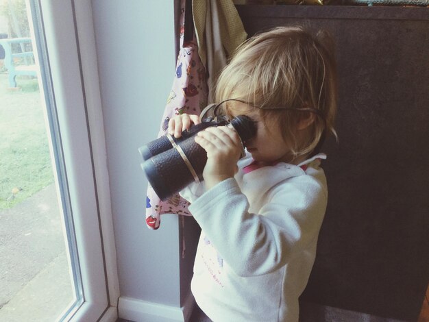 Foto een peuter die door een verrekijker kijkt