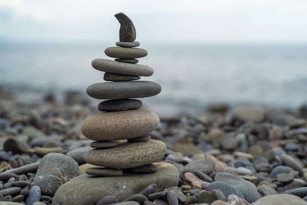 Een piramide van zeestenen op de achtergrond van de zee.