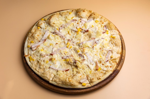 Een pizza met ananas erop op een houten bord.