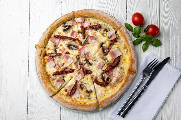 Een pizza met ham en champignons erop