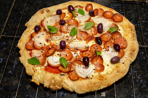 Een pizza met olijven, olijven en champignons op een rooster.