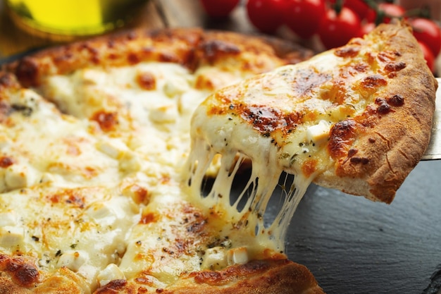 Een plak hete Italiaanse pizza met strekkende kaas Pizza vier kazen met basilicum