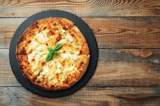 Een plak hete Italiaanse pizza met strekkende kaas Pizza vier kazen met basilicum