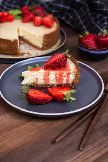 Een plakje cheesecake met aardbeien op een bord