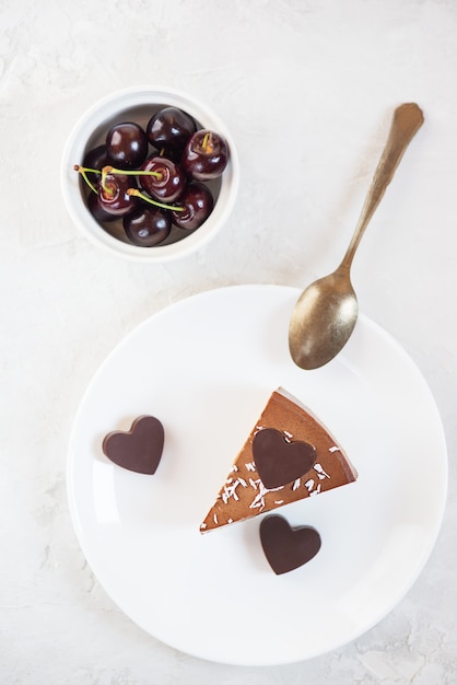 Een plakje mousse cake met chocolade hartjes