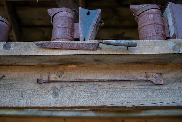 Een plank met verroeste metalen potten en een handvat met de tekst 'de oude'