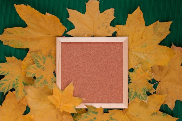 Een platte compositie met herfstbladeren en ruimte voor tekst op een houten achtergrond Herfstcompositie op een groene achtergrond Plat lag Uitzicht van bovenaf Ruimte om te kopiëren
