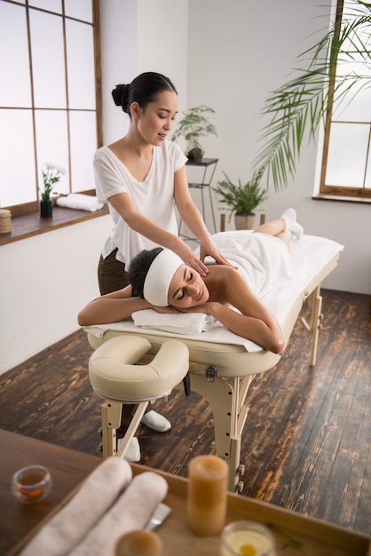 Foto een plezierige tijd. gelukkig ontspannen vrouw rusten in de spa salon terwijl u geniet van haar massage