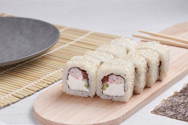 Een portie broodjes op een standaard, Japans eten, sushi op tafel, Chinese eetstokjes, lichte achtergrond