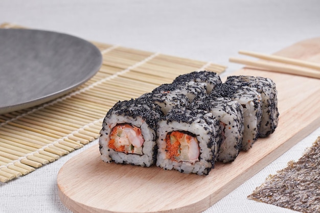 Een portie broodjes op een standaard, Japans eten, sushi op tafel, Chinese eetstokjes, lichte achtergrond