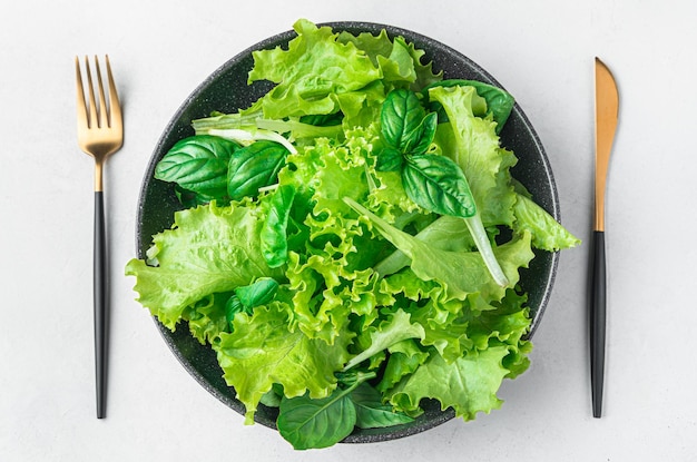 Een portie salade van een mengsel van verse bladeren in een bord op een grijze achtergrond