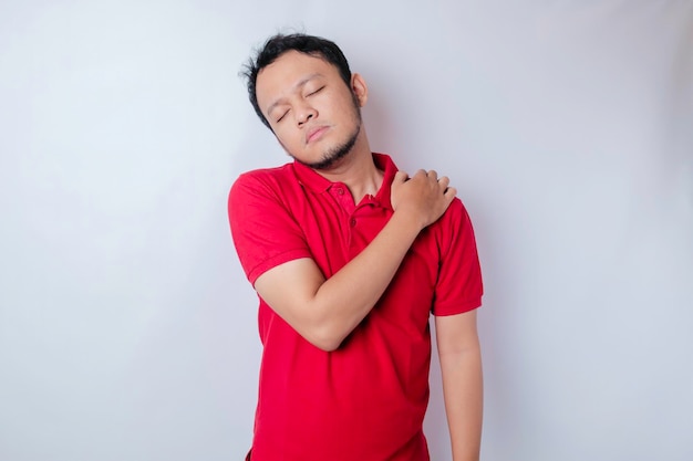Een portret van een Aziatische man heeft nek- en schouderpijn geïsoleerd door een witte achtergrond