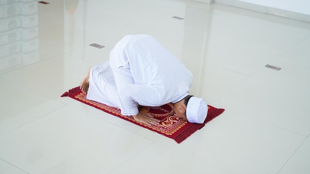 Een portret van een aziatische moslimman bidt in de moskee, de bidnaam is sholat, sujud-beweging op sholat