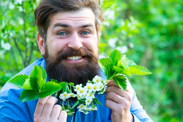 Een portret van een gelukkige man met witte bloemen op het hoofd, modefoto van de lenteman