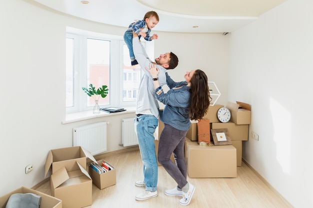 Foto een portret van een jong stel met een baby en bewegende kartonnen dozen in een nieuw huis