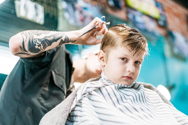 Een portret van een jongen die naar de kapper gaat in een schoonheidssalon voor mannen