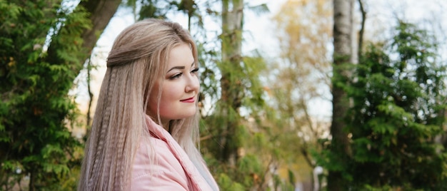 Een portret van een mooie vrouw zittend op een bankje in de buurt van de groene vegetatie