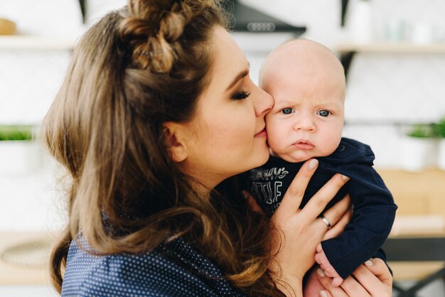 Een portret van mooie jonge blanke vrouw kuste haar baby