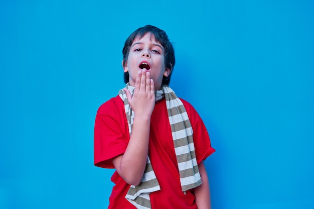 Een portret van verveelde jongen in rode t-shirt en sjaal