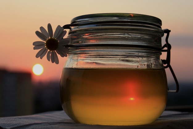 Foto een pot honing op de achtergrond van de zonsondergang